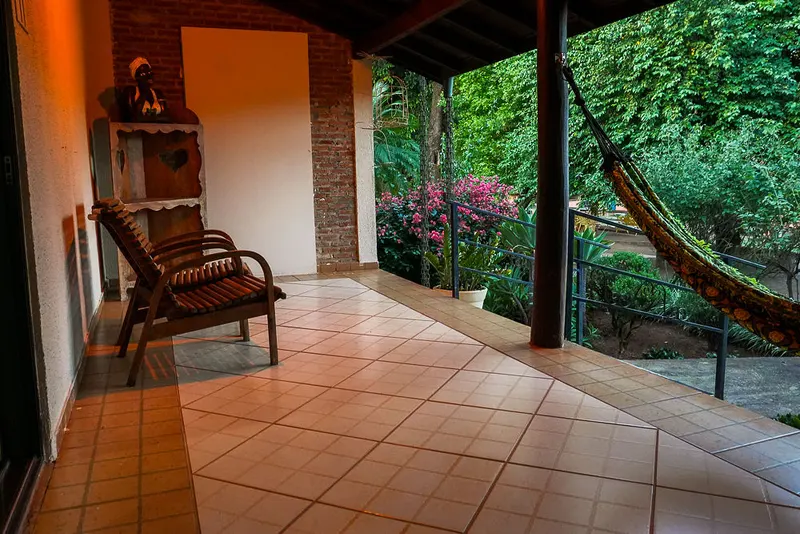 Varanda do chalé para 2 pessoas com rede e jardim florido