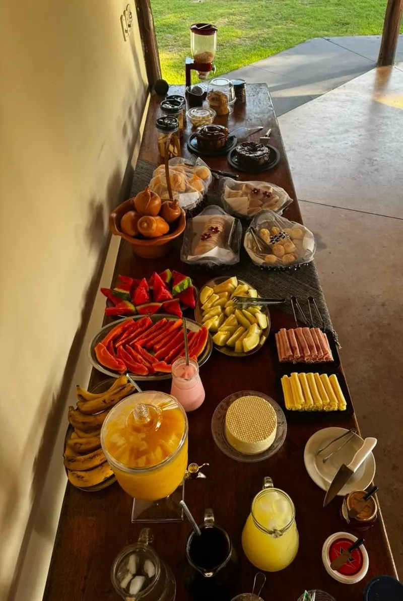 Mesa do café da manhã com frutas, pães, frios e sucos